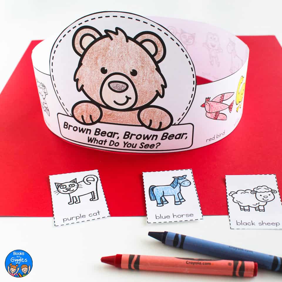 paper hat featuring a brown bear, shown with crayons and cutout pieces